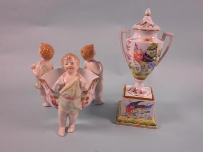 A continental porcelain two-handled urn and cover decorated with aesthetic pheasants