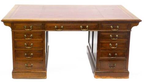 An early 20thC mahogany partners type pedestal desk, the rectangular top with a maroon leather inset and a moulded edge, above an arrangement of nine panelled drawers, on a plinth base, 78cm high, 167cm wide, 98cm deep.