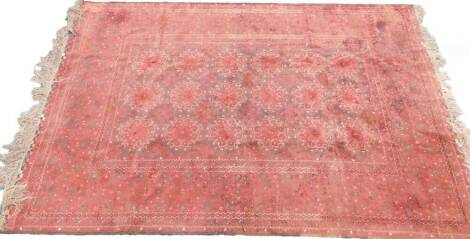 A Turkman carpet, with a design of medallions, on a deep red ground with one wide and multiple borders, 298cm x 208cm.