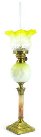 A Victorian brass oil lamp, with a small yellow and white frosted shade, brass fitting, the yellow and white opaque satin glass reservoir in the manner of Thomas Webb, on a pink alabaster and brass Corinthian column base, (AF), 56cm high overall.