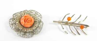 A marcasite and coral rose floral brooch, set in filigree white metal, together with a white metal and double amber ball olive branch brooch. (2)