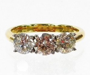 An 18ct gold diamond three stone ring, with three round brilliant cut diamonds, approx 5.2mm x 5.2mm x 3.8mm, totalling 1.65cts, in a white gold four claw setting, ring size M½, 3.7g all in.