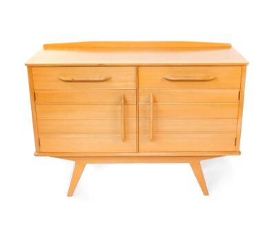 A Donald Gomme G-Plan 1950's light oak and beech sideboard, with a pair of drawers, one lined, over a pair of cupboard doors, raised on tapering diagonal legs, 88cm high, 124cm wide, 49cm deep.