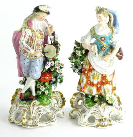 A pair of late 18thC Derby porcelain figures, each modelled in the form of a male and a female musician, on a pierced rococo scroll base, incised number 311 to underside, (AF), 19.5cm high.