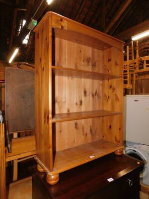 A pine bookcase enclosing two adjustable shelves, 102cm high, 75cm wide, 27cm deep.