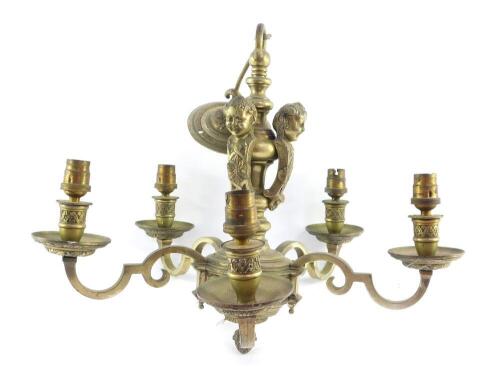 An early 20thC heavy brass five branch chandelier, embossed with leaves and cast with three figural monopodia , 40cm high, 45cm wide.