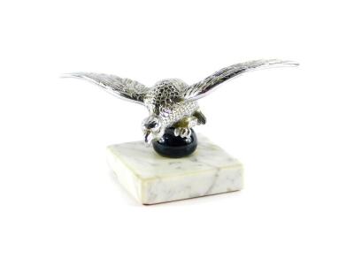 An Alvis 1930's chrome cast mascot, modelled as a Desmo Eagle raised on a ball, on a veined white marble base, 18cm wide.