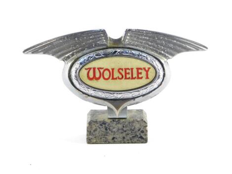 A Wolseley mid 20thC chrome light up grill badge, raised on a marble base, 16cm wide.