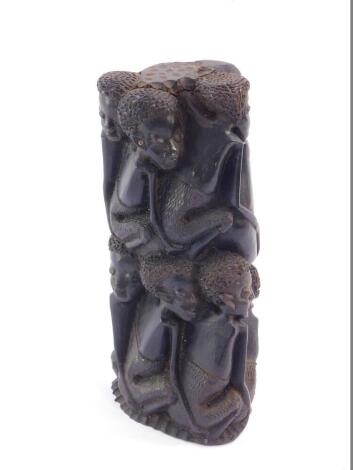 A Northern Mozambique Makonde ebony family tree carving, depicting two rows of eight crouching and embracing figures, 21.5cm high.