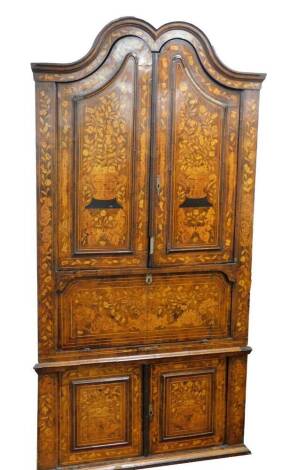 A 18thC Dutch marquetry corner cabinet, with fixed swan neck pediment, raised above heavily carved shelves and cupboard beneath, profusely decorated with leaves and flowers with a lower geometric inlay, fronted by two elaborate designed doors, 243cm high,