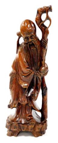A Chinese root carving of a bearded sage, holding a staff on a shaped base, probably early 20thC, unsigned, 32cm high.