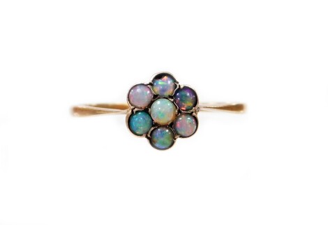 An opal daisy ring, the small daisy cluster set with an arrangement of opals, in yellow metal setting, on a pierced basket, unmarked, ring size L½, unmarked, 0.7g all in.