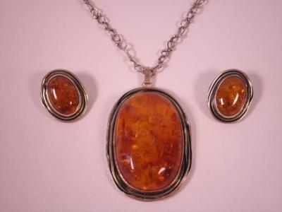 A modern silver and composite amber pendant and matching earrings<br