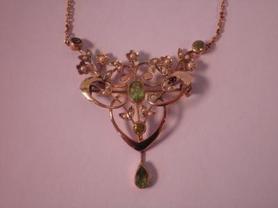 An Edwardian pendant/brooch of open lobed scroll form with a central