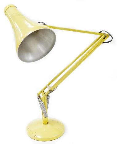 A Herbert Terry and Sons vintage angle poise lamp, with cone shaped shade, 23cm wide, on circular foot, with articulated stem, in yellow.