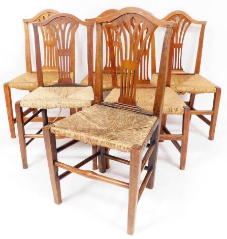 A set of six late 19thC elm dining chairs, with camel backs having pierced back splats, fixed rush seats and front tapering square legs, 97cm high.