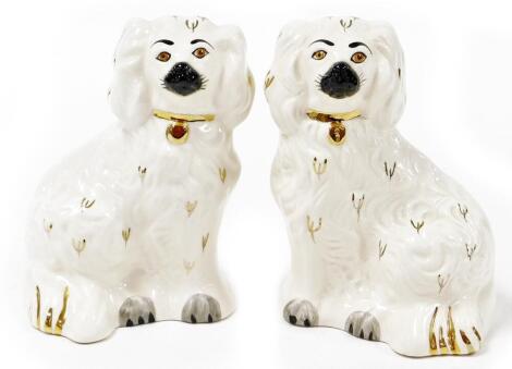 Two Royal Doulton miniature Staffordshire style Spaniels, in white with gold collars, stamped to the base, 15cm high.