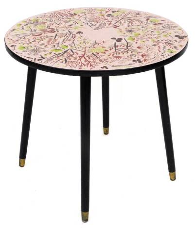 A vintage 1960's/70's side table, with pink/red coloured top, bearing flowers leaves and berries, with black border on four black stem legs, with brass castors, 56cm high, 60cm diameter,