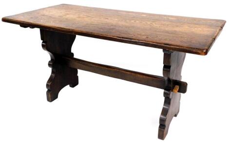 A 20thC oak plank top refectory table, with oblong top on shaped legs, joined by a horizontal block stretcher, 77cm high, 151cm wide, 74cm deep.