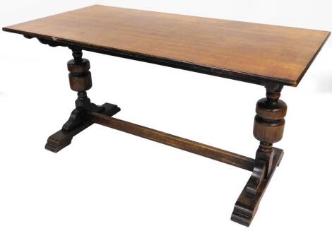 A 20thC oak refectory table, the plain rectangular top on heavy double inverted supports joined by a horizontal stretcher terminating in stepped scroll feet, 77cm high, 152cm wide, 66cm deep.