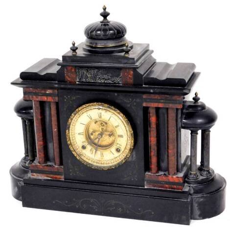 A Victorian slate and marble mantel clock, in an architectural case, surmounted by a compressed dome raised above a fancy Roman numeric dial flanked by fluted and plain columns on a shaped base, with an eight day key wind movement, striking on the half ho