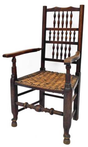 A late 19thC rush seated oak framed carver chair, with three section bobbin turned back, on splayed arms, with rush seated seat, on H stretcher, bobbin turned base, on spade feet, 107cm high, 62cm wide.