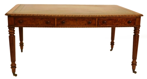 An early Victorian walnut writing table, the rectangular top with a green tooled leather insert and a carved border, above three frieze drawers on reeded tapering legs with brass castors, 74cm high, 152cm wide, 101cm deep.