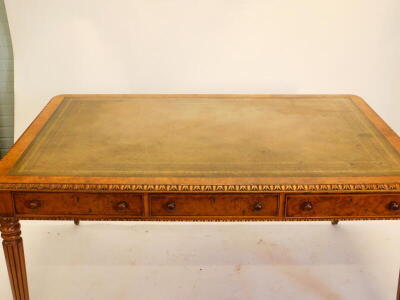 An early Victorian walnut writing table, the rectangular top with a green tooled leather insert and a carved border, above three frieze drawers on reeded tapering legs with brass castors, 74cm high, 152cm wide, 101cm deep. - 2