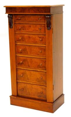 A walnut Wellington chest in Victorian style, the figured top with a moulded edge, above an arrangement of seven feather banded drawers, each with turned wood handles and hinged stays, on a plinth, 62cm wide, 41cm deep.