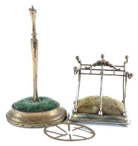 An Edwardian silver hat pin holder, modelled in the form of an umbrella stand, on a weighted moulded base with bun feet, Birmingham 1904, by Sydney and Co, and another similar, (AF).