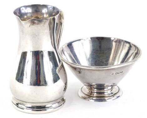 A George V Art Deco silver cream jug and matching sugar bowl, each of plain form and a moulded foot, Sheffield 1924, by Thomas Bradbury and Sons, 7½ oz, overall.