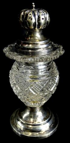 An early 19thC cut glass and silver sugar castor, the pierced lid with reeded borders, the hob nail cut base decorated with a shaped band, on a domed reeded foot, weighted, marks indistinct, 13cm high.