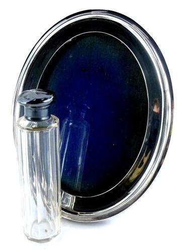 A George V silver oval photograph frame, with oak backing, 21cm x 16cm, and a silver mounted glass dressing table jar, (2).