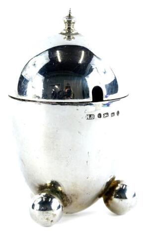 An Art Deco bullet shaped silver mustard pot, with a turned finial and three bun feet, Birmingham assay date letter indistinct, 2oz.