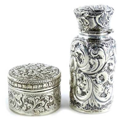 An embossed silver scent bottle, with glass liner, the lid (AF), marks indistinct and a continental white metal pill box, weighable silver 1¼oz.