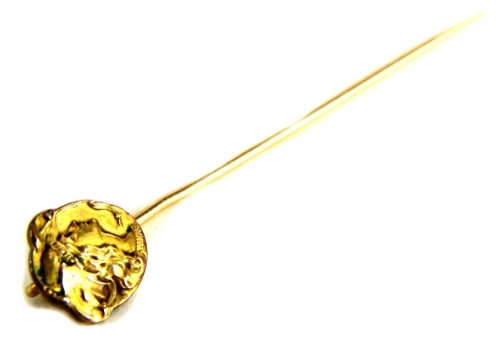 An Art Nouveau stick pin, with circular head depicting a maidens head, yellow metal, unmarked, 6cm long.