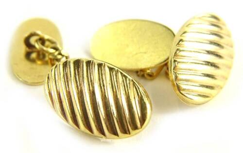 A pair of 9ct gold oval cufflinks, the oval rivetted cufflink head on single chain, 3.2g.