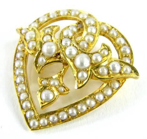 A heart shaped seed pearl pendant/brooch, in heart shaped design set with seed pearls, in a yellow metal setting, marked 15ct 10693, with pendant clip and two screw holes possibly for a brooch fitting, 2.5cm x 3cm, 4.5g all in.