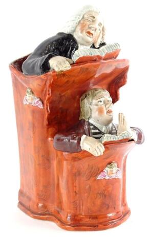 An early 19thC Staffordshire pottery pulpit group, depicting the Vicar and Moses, picked out in red, after Ralph Wood, 21cm high.