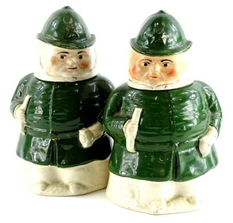 A pair of 19thC Staffordshire jars and covers, each modelled in the form of a policeman wearing a green uniform, picked out in gilt, 19cm high.