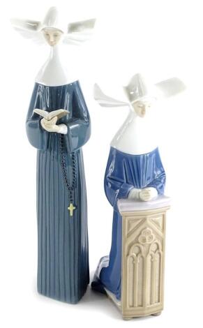 A Lladro porcelain nun holding a prayer book, 26cm high, and a Lladro praying nun, (2).