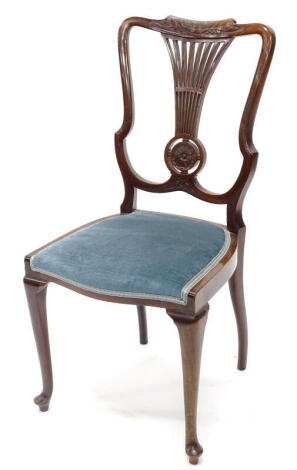 An Edwardian mahogany bedroom chair, the shield shaped back with a pierced splat carved with a central patera, with a blue padded seat on cabriole legs.