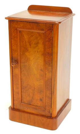 A Victorian walnut and burr walnut pot cupboard, with a raised gallery above a panelled door with turned wooden handle on a plinth, 81cm high, 33cm deep, 39cm wide.