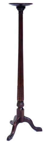 A mahogany plant stand, with a circular dish top on a leaf carved fluted column and tripod base, 59cm high, the top 29cm diameter.