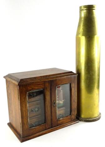 An early 20thC oak smoker's or tobacco cabinet, with a fitted interior of drawers and a glazed terracotta tobacco jar and cover, with a hunting design in silhouette, stamped Langley (jar AF) 32cm wide.