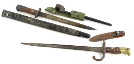 A bayonet stamped GR1 mark MK3, with mahogany handle and associated scabbard, a 19thC French bayonet with mahogany and brass mounts, a spike bayonet and two miniature daggers in leather scabbard (4).