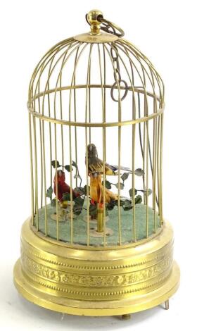 A continental pressed brass three bird musical bird cage, on a circular base (AF), 28cm high.