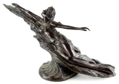 An Art Nouveau style bronze figure of a female nude in a reclining pose, on a circular base, unsigned, 93cm wide.