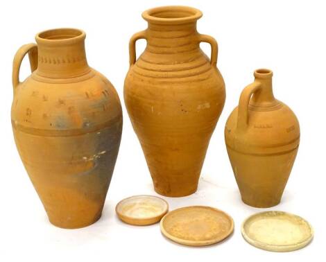 Three continental unglazed terracotta vessels, each of tapering form, with bases, the largest 62cm high.