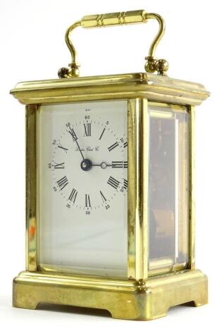 A brass carriage time piece, the enamel type dial signed London Clock Company, and with Roman numerals, 15cm high.